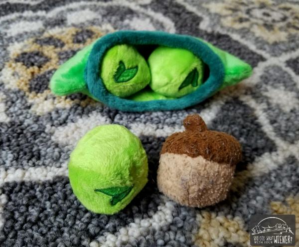 BarkShop Pea next to an acorn toy. They're about the size of a golf ball.
